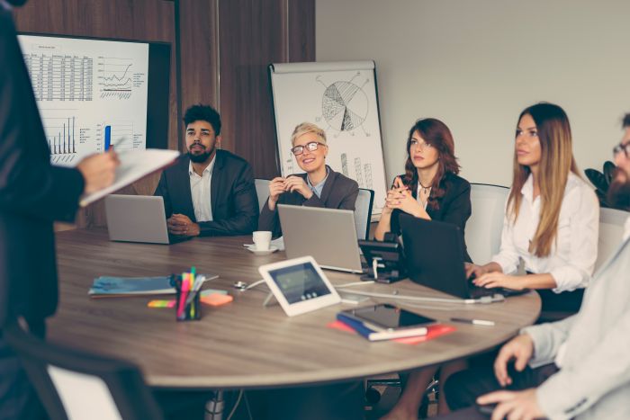 Réunion d'entreprise autour d'une table avec documents financiers